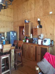 una cocina con armarios de madera y una mesa en una habitación en Casa Playa en Navidad