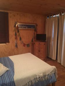 ein Schlafzimmer mit einem Bett und einem TV in der Unterkunft Casa Playa in Navidad