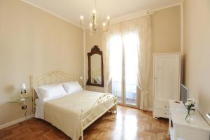 1 dormitorio con cama, espejo y ventana en Residenza Borbonica, en Nápoles