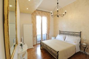 una camera da letto con un letto con uno specchio e un lampadario a braccio di Residenza Borbonica a Napoli