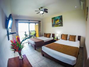 una camera d'albergo con due letti e una televisione di Eco Boutique Hotel Vista Las Islas Reserva Natural a Paquera