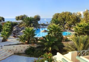 a view of a resort with palm trees and a pool at Atlantis Beach Villa in Perivolos
