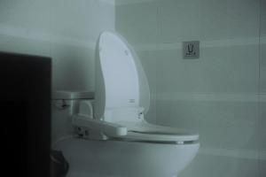 a white toilet with the lid up in a bathroom at Zen Box House in Yangshuo