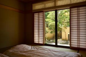 Postel nebo postele na pokoji v ubytování Guesthouse Nijo Fukuro-Tei