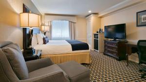 um quarto de hotel com uma cama e uma televisão de ecrã plano em Best Western Plus Puyallup Hotel em Puyallup