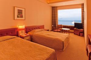 a hotel room with two beds and a television at Kussharo Prince Hotel in Teshikaga