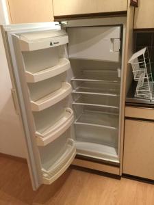 einem leeren Kühlschrank mit offener Tür in der Küche in der Unterkunft Disentis in Disentis
