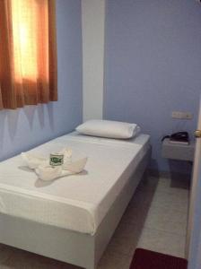 Una cama blanca con una toalla en una habitación en UKL Ever Resort Hotel, en Laoag