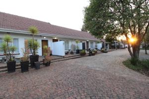 a building with potted plants in front of it at Wilger Guesthouse in Centurion