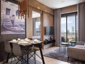 a dining room with a table and chairs and a living room at One Residence Hotel & Apartment in Phnom Penh