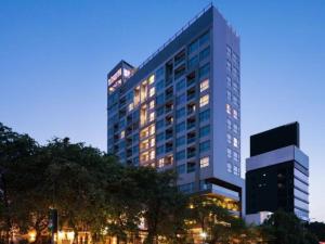 a tall building with lights in front of it at One Residence Hotel & Apartment in Phnom Penh