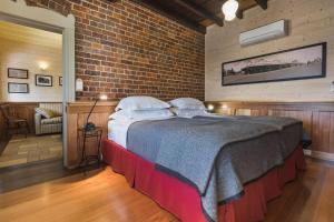 a bedroom with a large bed in a brick wall at Old Bank Boutique Hotel in Mittagong