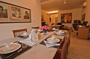 a dining room with a table with plates and napkins at Colonel’s Retreat in New Delhi