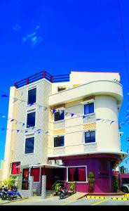 a tall white building with red and blue windows at Domsowir Hotel and Restaurant in Borongan