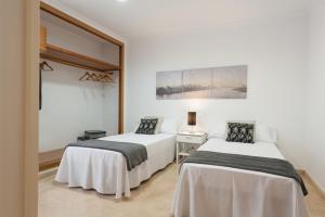 two beds in a room with white walls at Can Gual in Inca