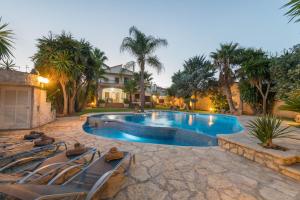 a swimming pool with lounge chairs next to a house at Can Gual in Inca