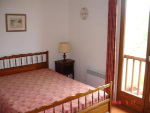 een kleine slaapkamer met een bed en een raam bij Les Bastidons in Sainte-Maxime +4 foto's