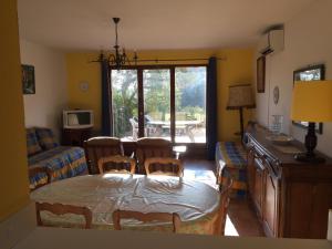 een woonkamer met een tafel en stoelen en een eetkamer bij Les Bastidons in Sainte-Maxime