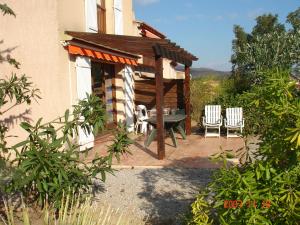 um gazebo com uma mesa e cadeiras num pátio em Les Bastidons em Sainte-Maxime