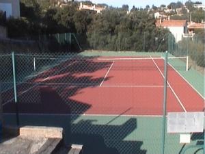 a tennis court with a net on top of it at Les Bastidons in Sainte-Maxime