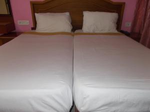 two twin beds with white sheets and pillows at KTDC Tamarind Easy Hotel in Guruvāyūr