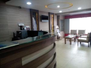 a bar in a restaurant with a counter and chairs at Hotel Preethi Palace in Ooty