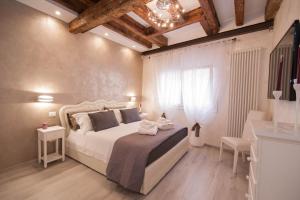 um quarto com uma grande cama branca e uma janela em Ca del Pape em Veneza