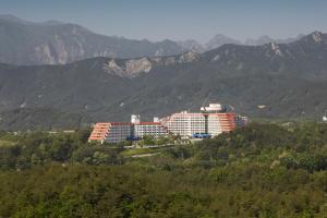a building on a hill with mountains in the background at Hyundai Soo Resort Sokcho in Sokcho