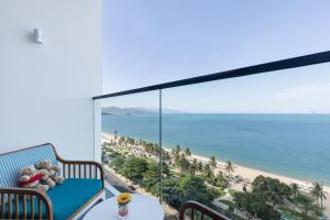 a balcony with teddy bears sitting on a chair looking at the beach at Citadines Bayfront Nha Trang in Nha Trang