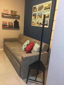 uma sala de estar com um sofá e uma cadeira preta em Loft New York em Niterói