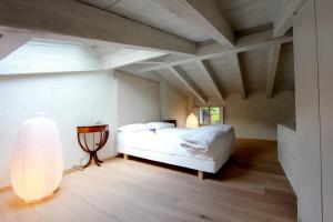 a bedroom with a white bed and a lamp at Casa della Pianista in Gargnano