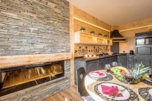 kuchnia ze stołem i kamienną ścianą w obiekcie Apartament Owcze Runo Zakopane w Zakopanem
