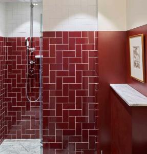 La salle de bains est pourvue d'une douche et de carrelage rouge. dans l'établissement Maison Malesherbes, à Paris