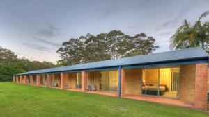 a brick house with a black roof at Yarra Holiday Park in Stuarts Point