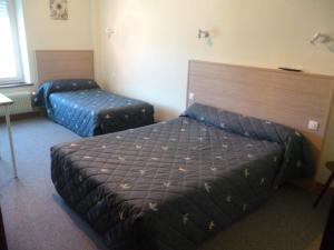 una habitación de hotel con 2 camas en una habitación en Hôtel Relais des Vosges, en Monthureux-sur-Saône