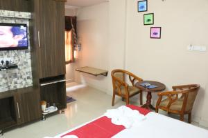 a living room with a bed and a tv at Hotel Akshaya in Visakhapatnam