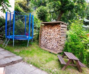 a chair and a pile of fire wood next to a wooden structure at Ferienwohnung Talblick in Eisenach