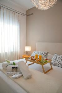 a white room with a bed and a table with drinks on it at Knossos by Heloni Apartments in Heraklio