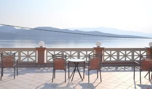 eine Terrasse mit Stühlen, einem Tisch und Blick auf das Wasser in der Unterkunft Florena Hotel in Nikiana