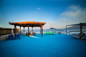 a deck with chairs and a pavilion on the water at Villa Mare Zakynthos, private in Laganas