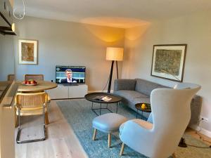 a living room with a couch and a tv at Kleiner Ulenhof in Wenningstedt