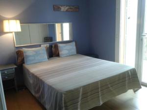 a bedroom with a large bed with blue walls at Apartamento Playa in Denia