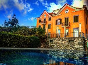 um grande edifício laranja com uma piscina em frente em Quinta Paços do Lago em Funchal