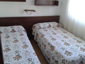 two beds sitting next to each other in a bedroom at Casa Flori in Celorio