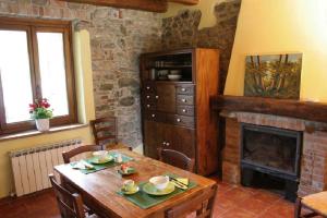 a living room with a wooden table and a fireplace at Cascina Formighezzo in Arquata Scrivia