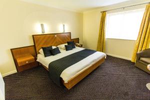 a hotel room with a large bed and a window at Padbrook Park Hotel in Cullompton +19 photos
