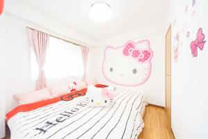 a bedroom with a bed with an hello kitty headboard at Awaji Central Room NC03 in Awaji