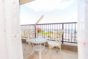 a table and chairs on a balcony with a view of the ocean at Awaji Central Room NC03 in Awaji +65 photos