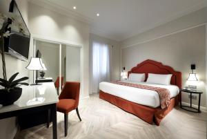 pokój hotelowy z dużym łóżkiem i biurkiem w obiekcie Eurostars Regina w Sewilli