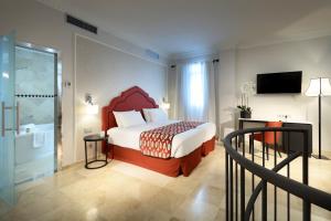 a hotel room with a bed and a balcony at Eurostars Regina in Seville